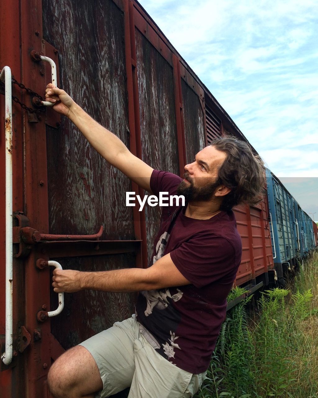 Bearded man hanging on train