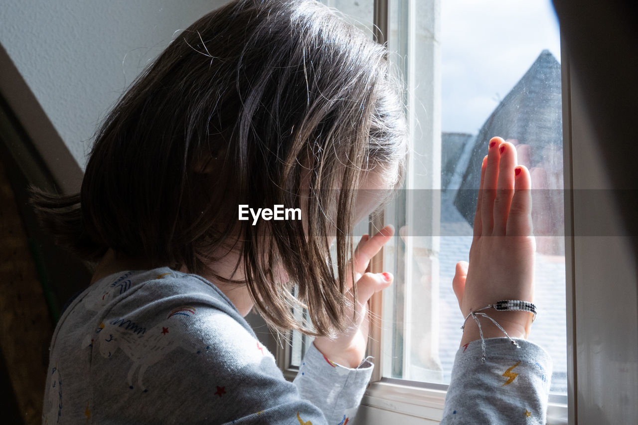 Girl looking through window