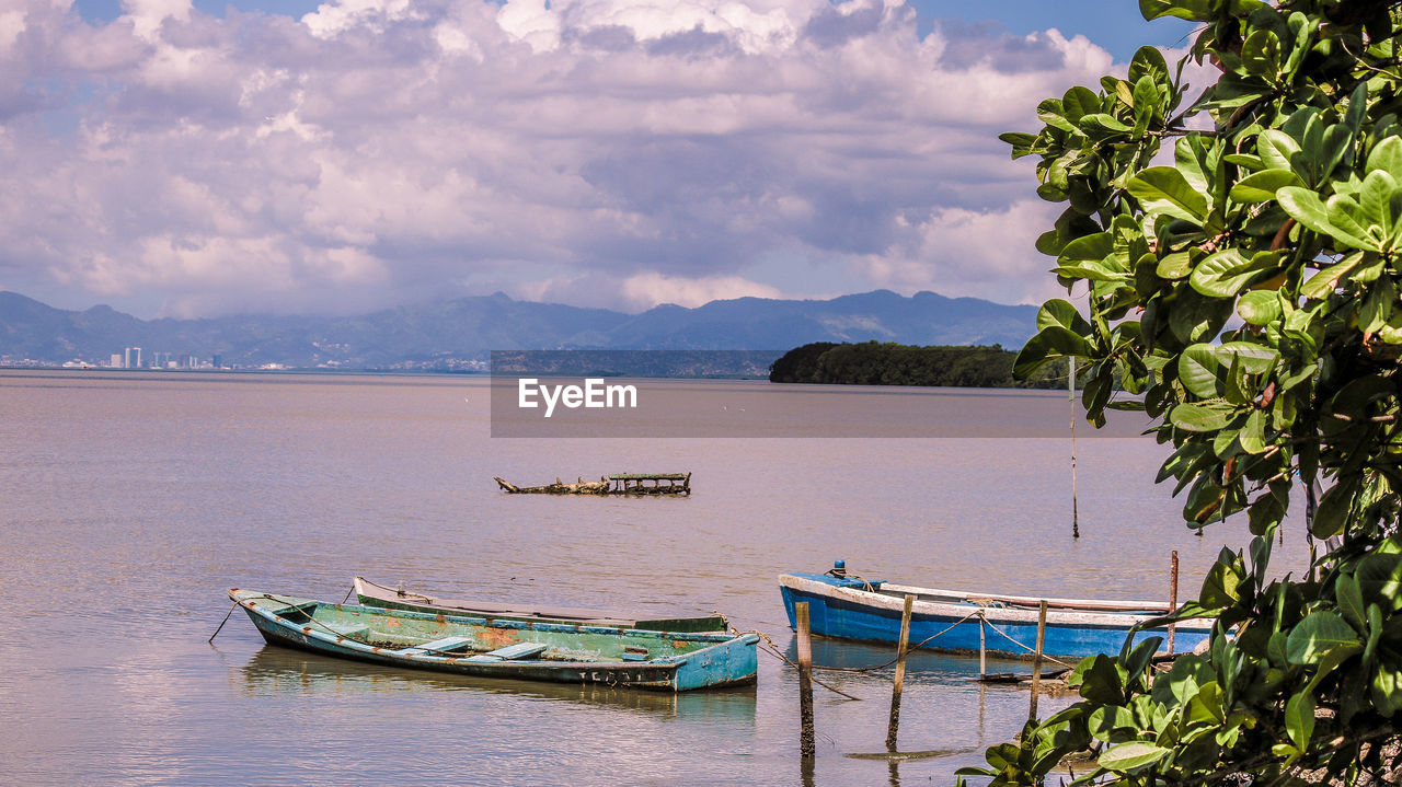 Boats moored on sea against sky