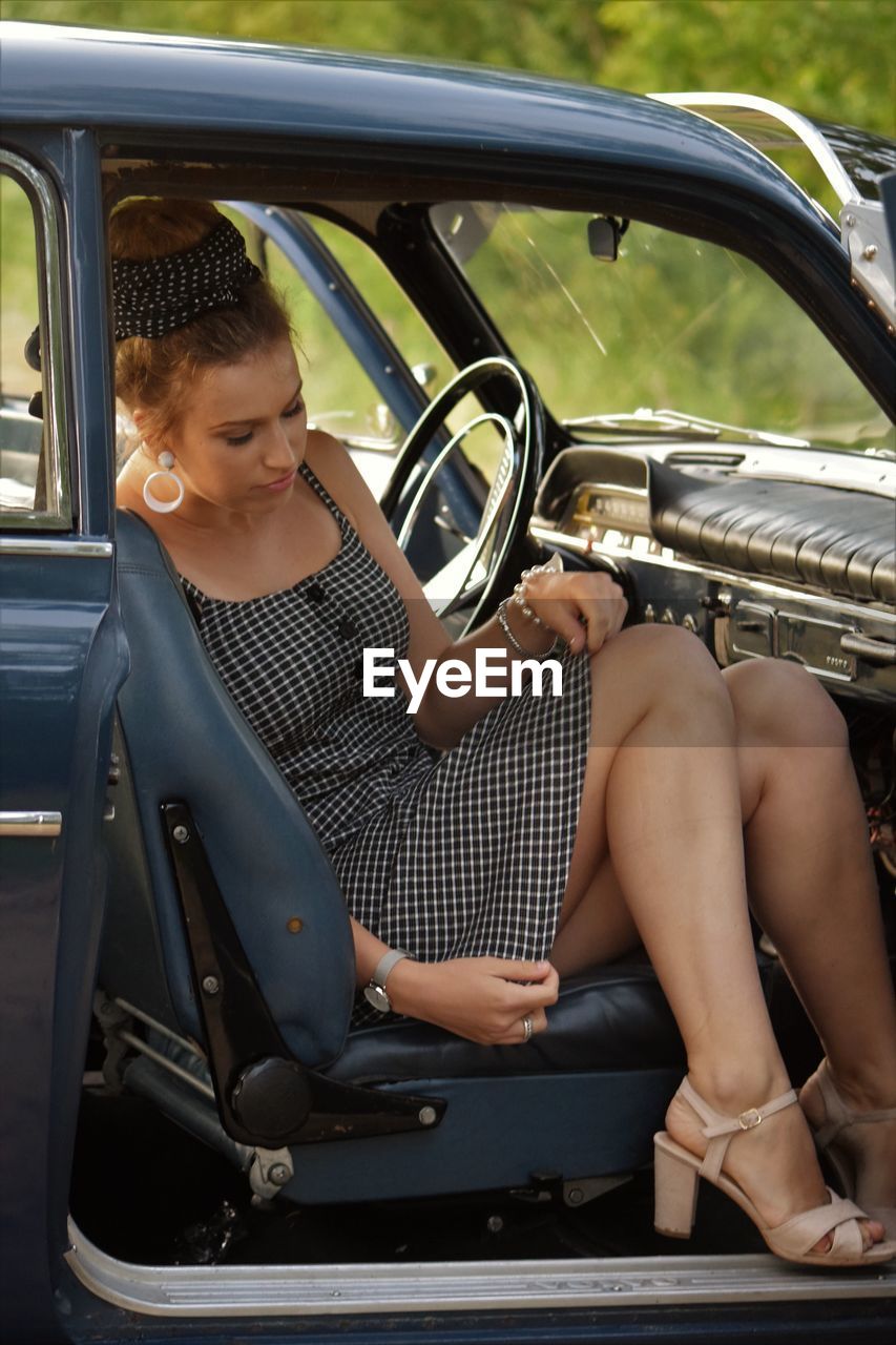 Young woman sitting in car