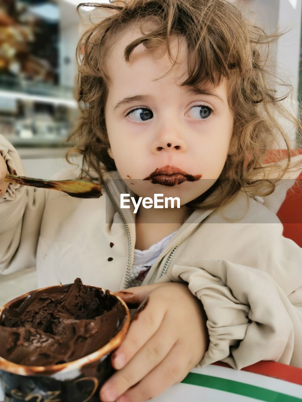 View of a cute girl eating chocolate ice cream