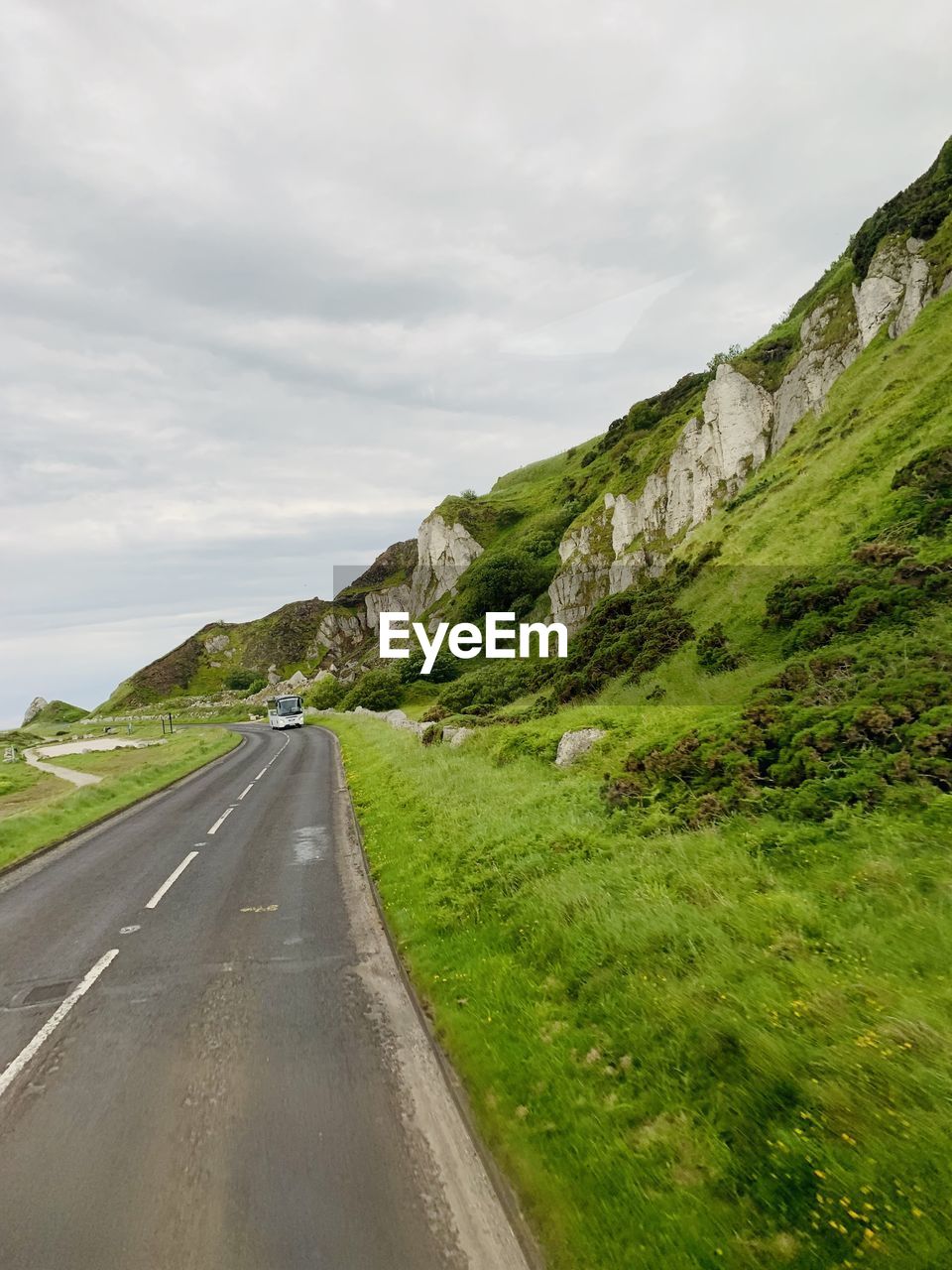 Road leading towards mountains against sky