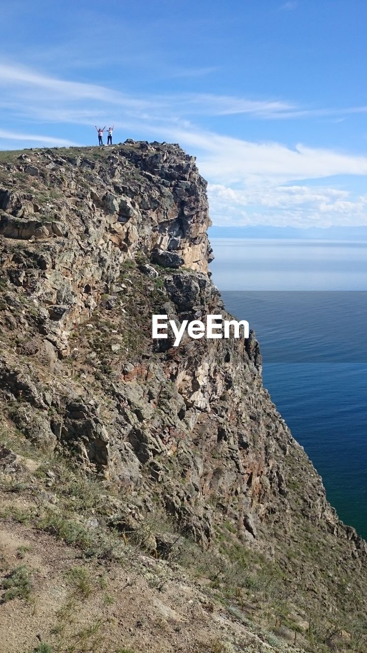 SCENIC VIEW OF CLIFF BY SEA AGAINST SKY