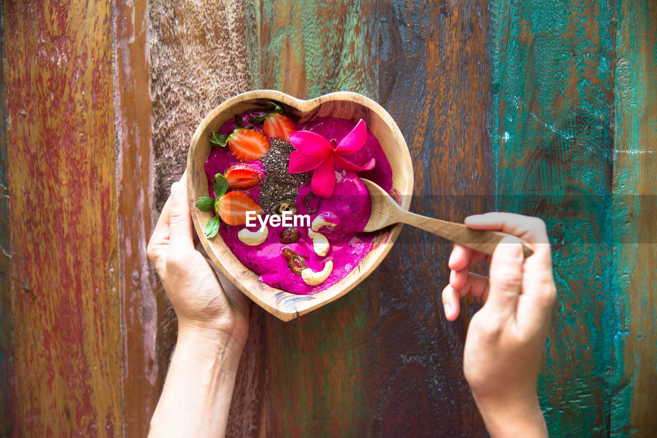 DIRECTLY ABOVE SHOT OF WOMAN HOLDING PINK FLOWER IN POT