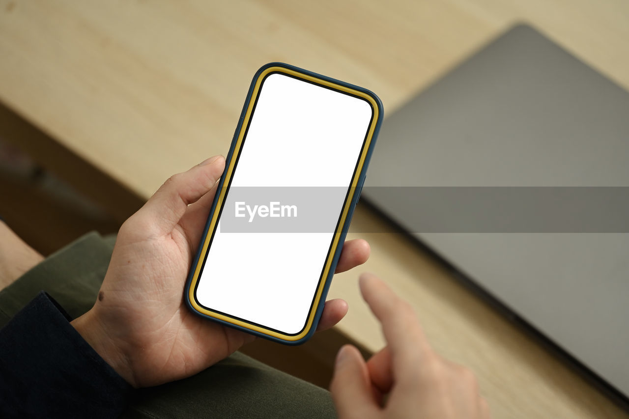 cropped hand of woman using mobile phone