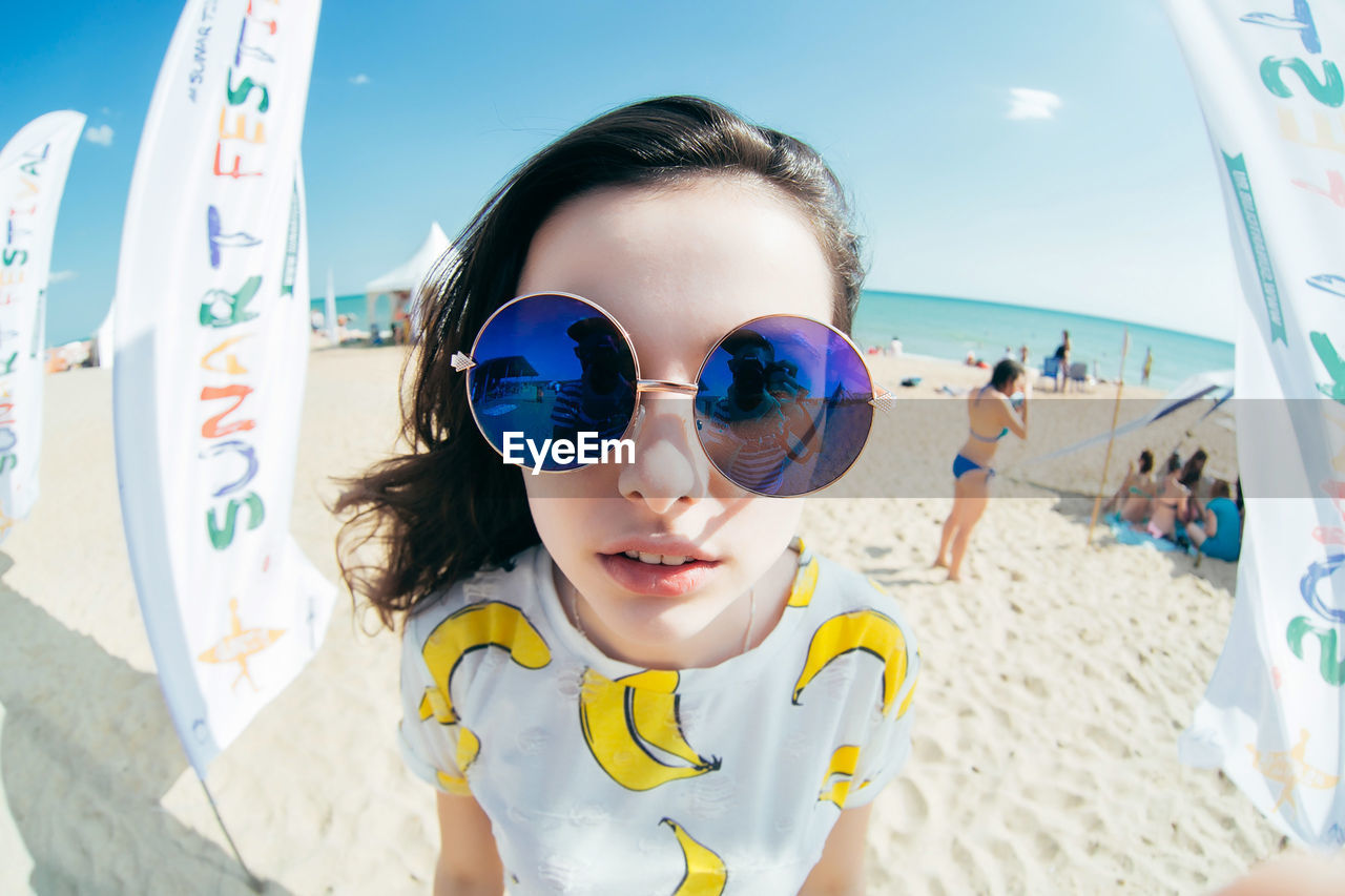 Portrait of woman wearing sunglasses at beach