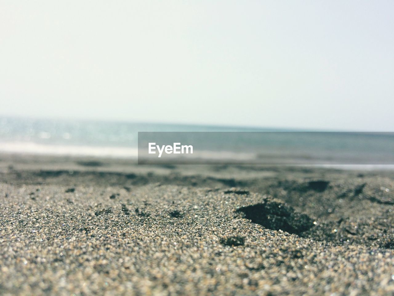 CLOSE-UP OF BEACH AGAINST CLEAR SKY