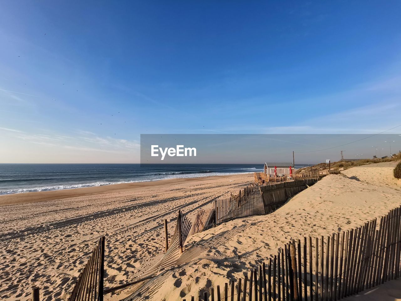 Scenic view of beach against blue sky