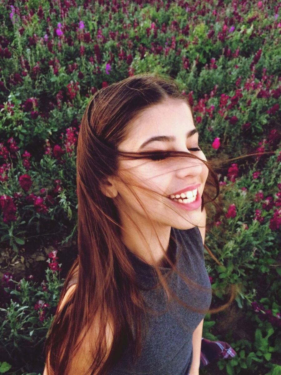 Portrait of young woman standing in flowers