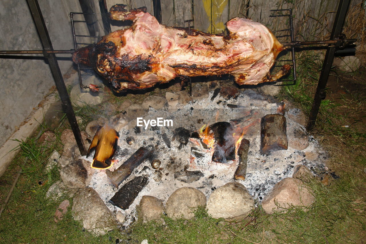 HIGH ANGLE VIEW OF BURNING ON BARBECUE