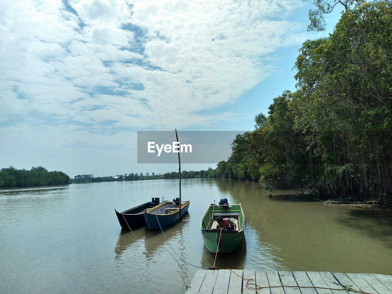 BOATS MOORED ON LAKE AGAINST SKY