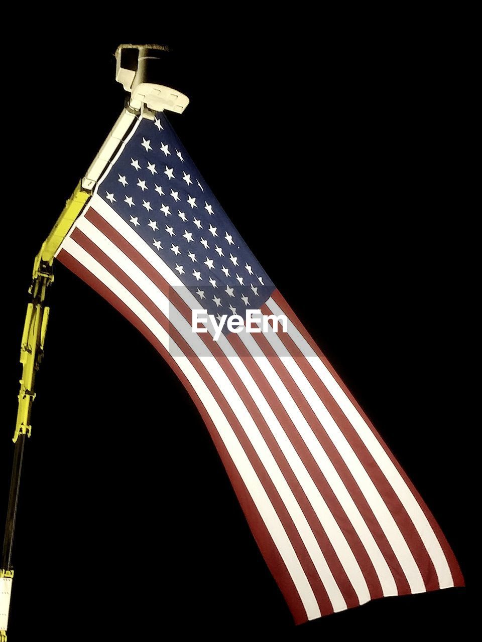 Low angle view of american flag against black background