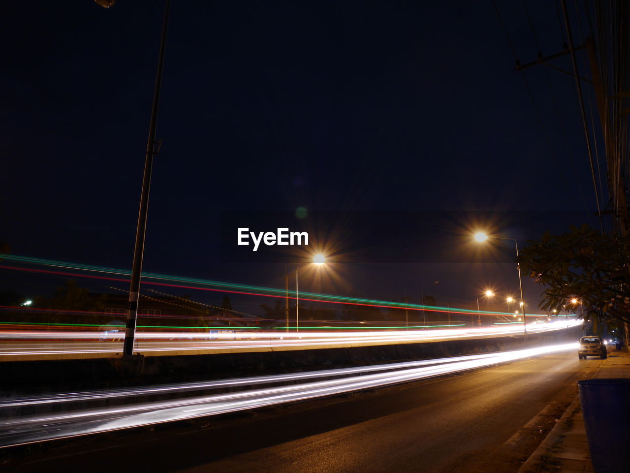 LIGHT TRAILS ON ROAD AGAINST SKY