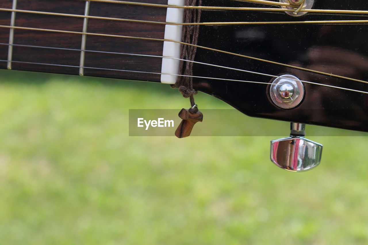 CLOSE-UP OF GUITAR ON THE GROUND