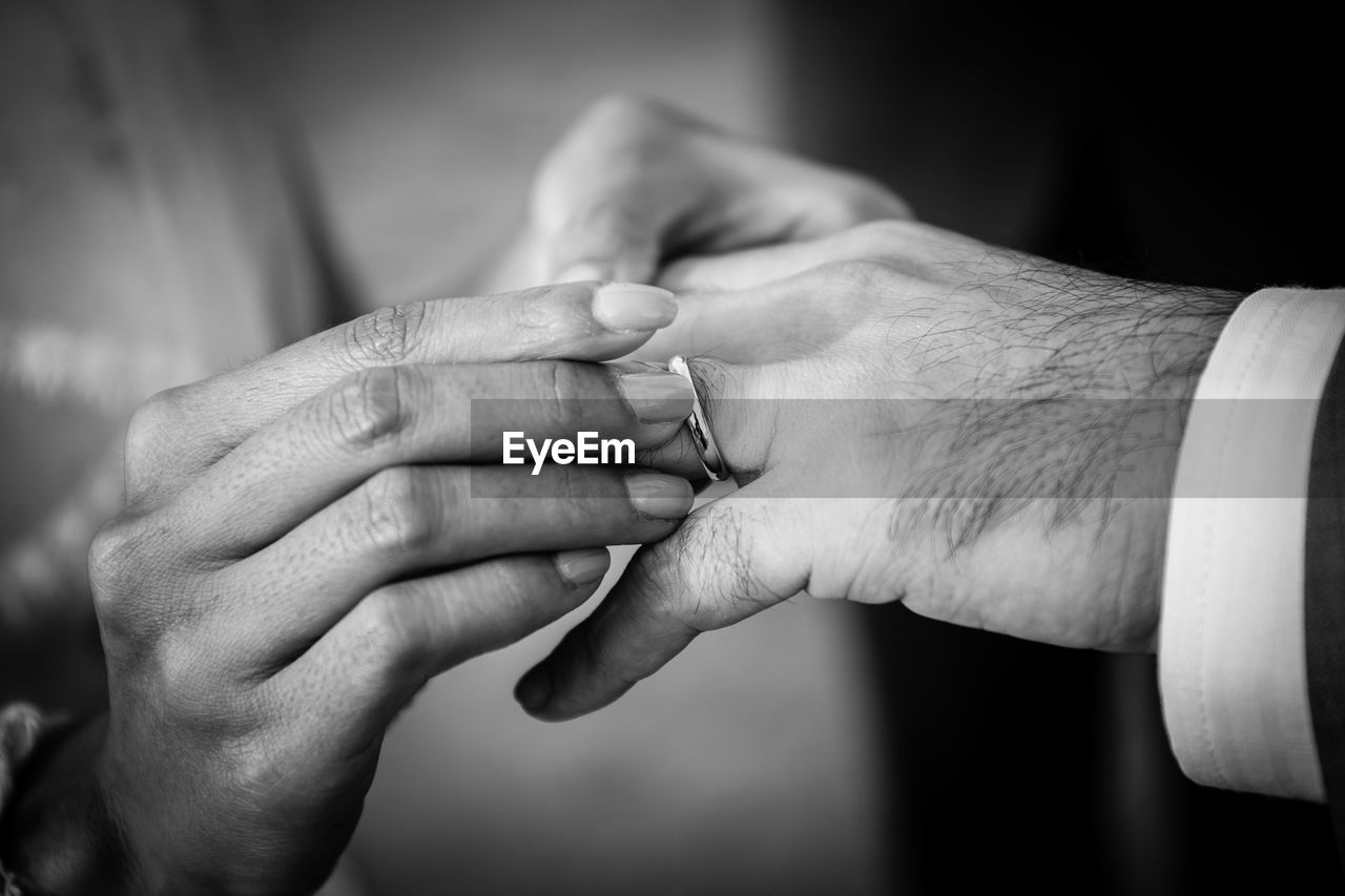 Close-up of woman putting ring on man