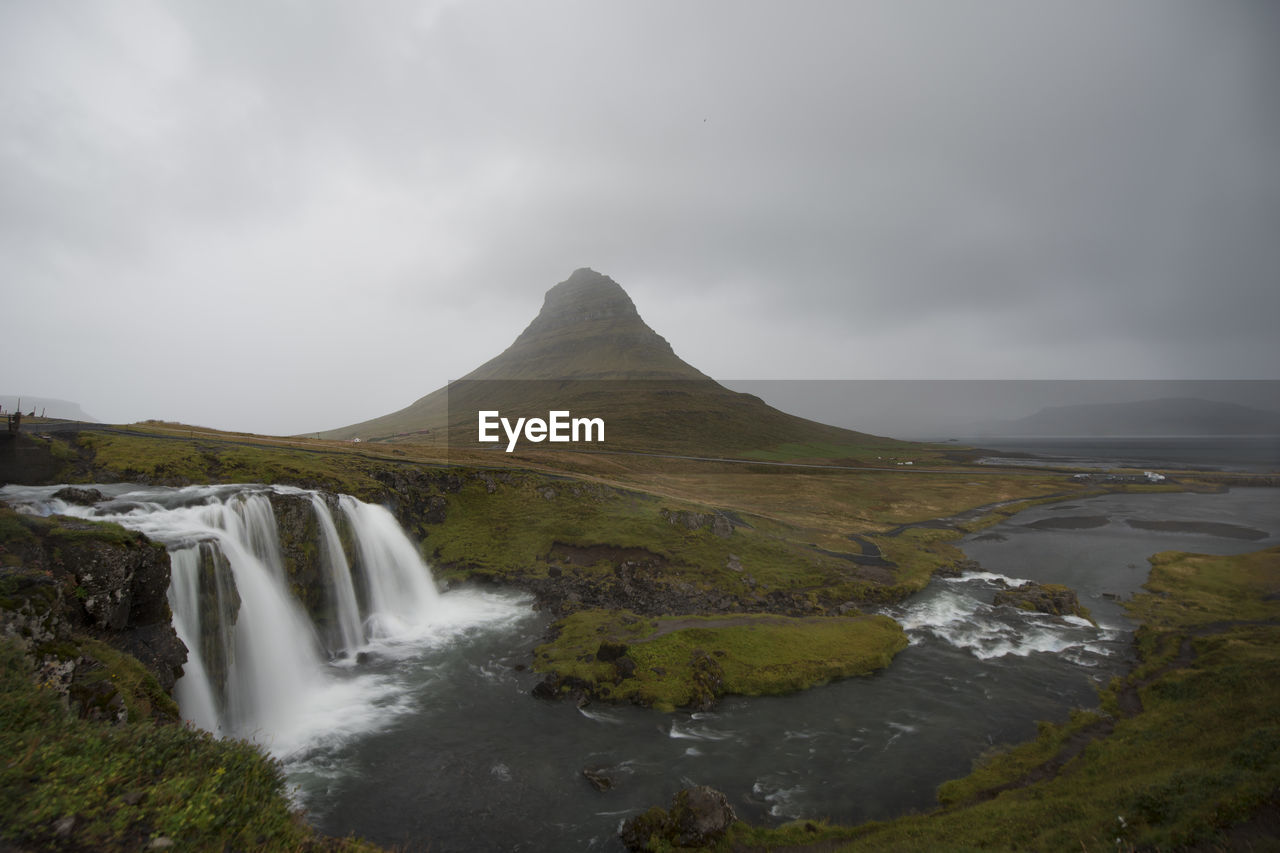 Scenic view of waterfall against sky