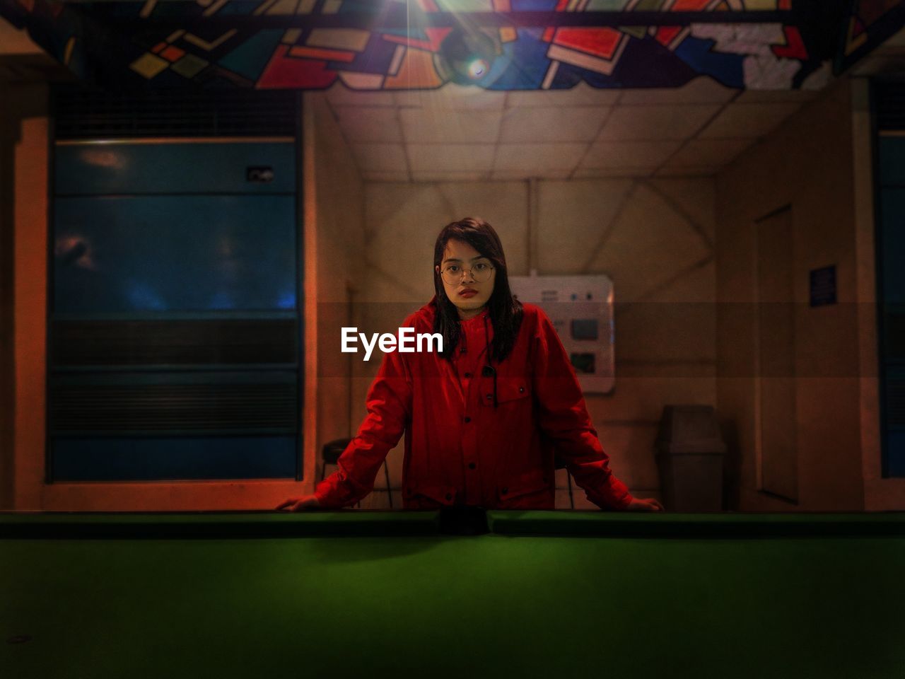 Portrait of woman standing by pool table