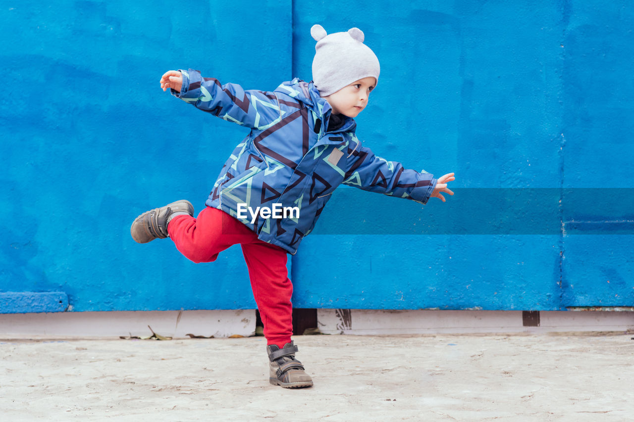 A cheerful child outdoors expresses himself through movement. power, joyful, rhythm, emotion. 