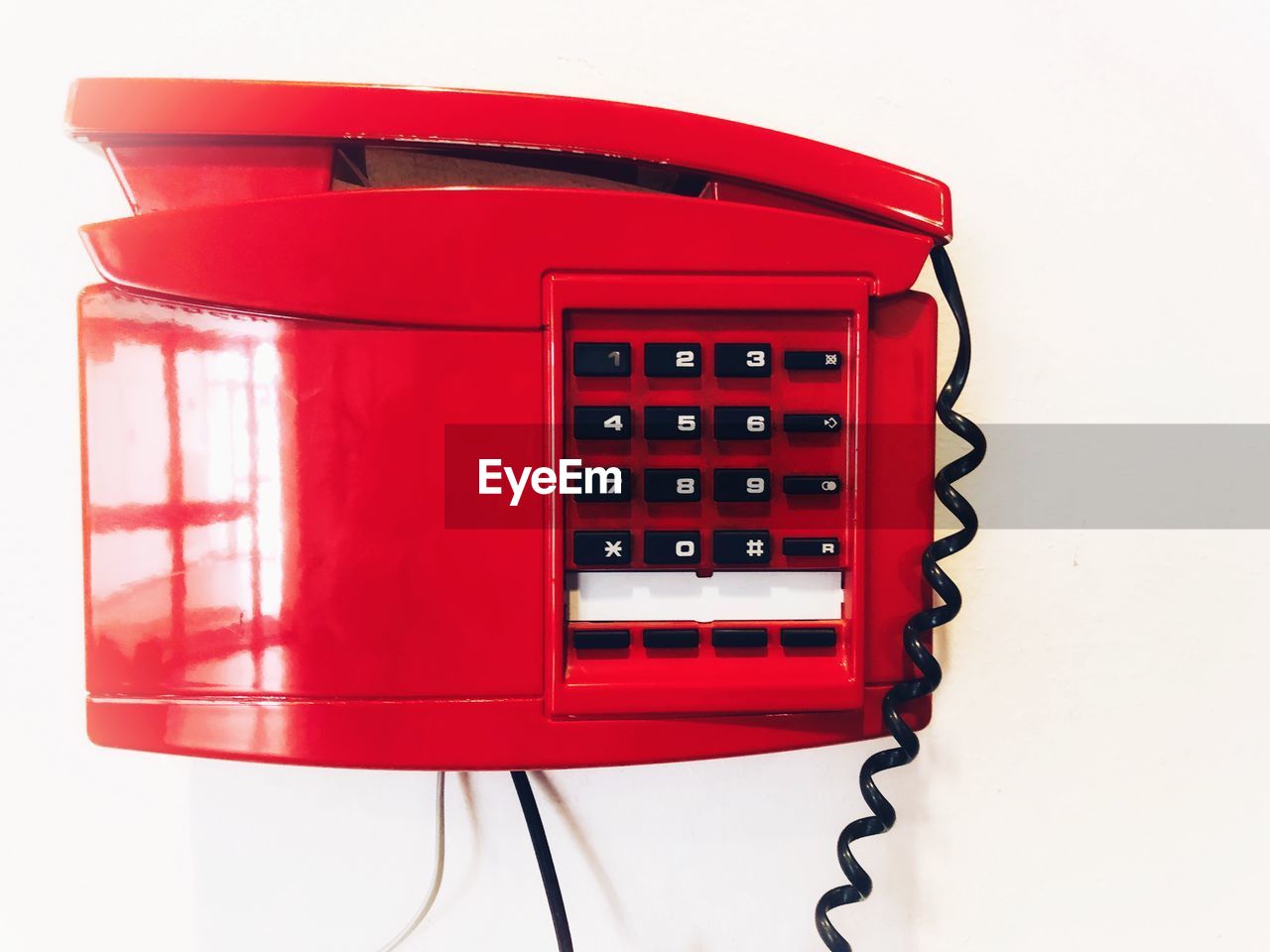 Close-up of red pay phone against white background