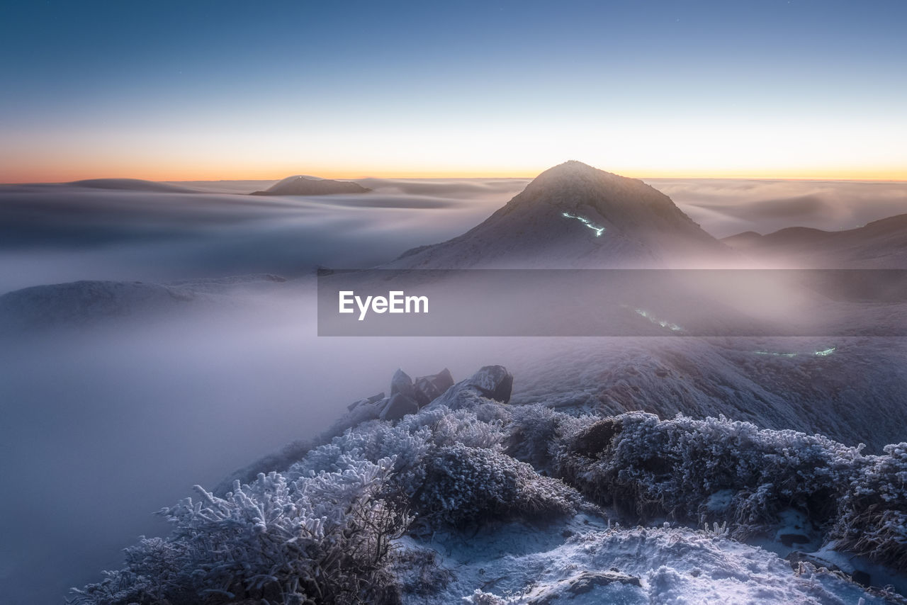 A mountain is surrounded by a sea of clouds