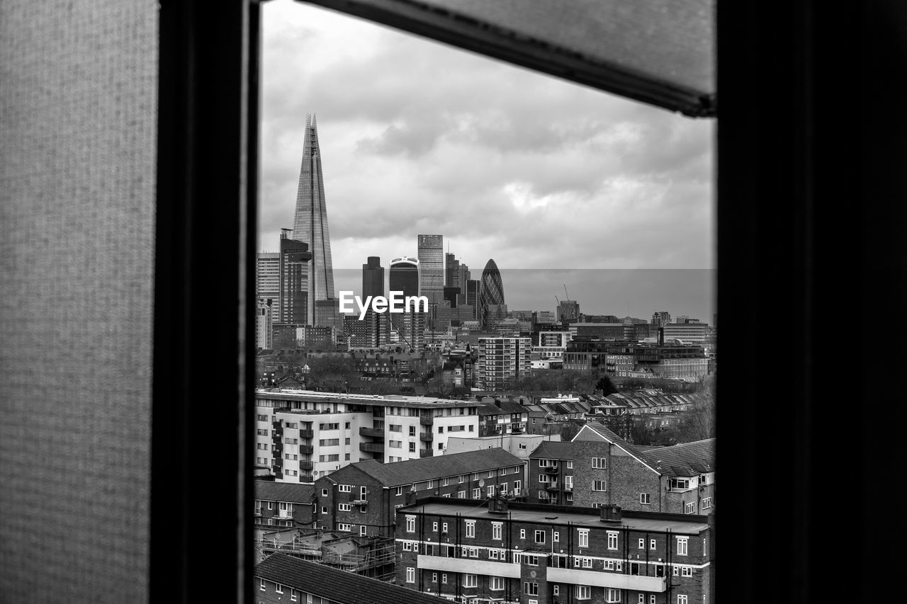 Shard london bridge amidst buildings seen through window in city