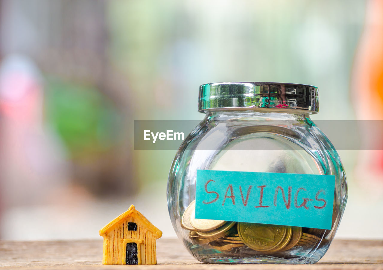 Close-up of coins in jar on wooden table