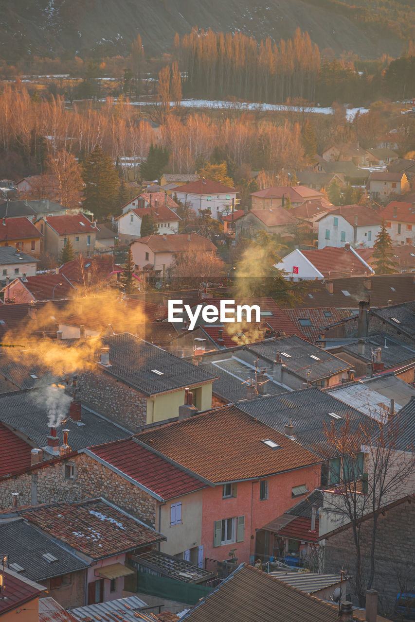 A vertical shot of the buildings in the old town of a town in the alps during the sunset in winter