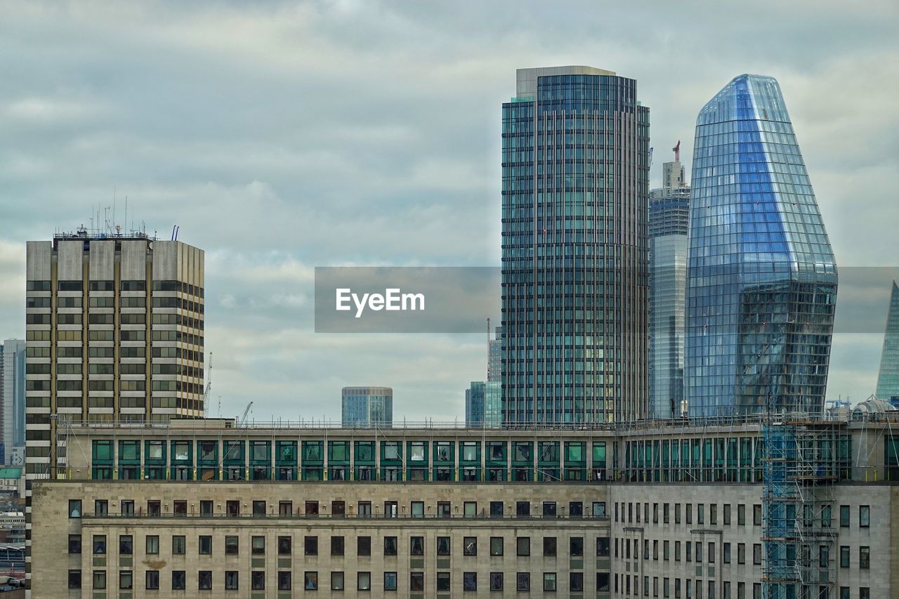 MODERN BUILDINGS AGAINST SKY IN CITY AGAINST CLOUDY DAY