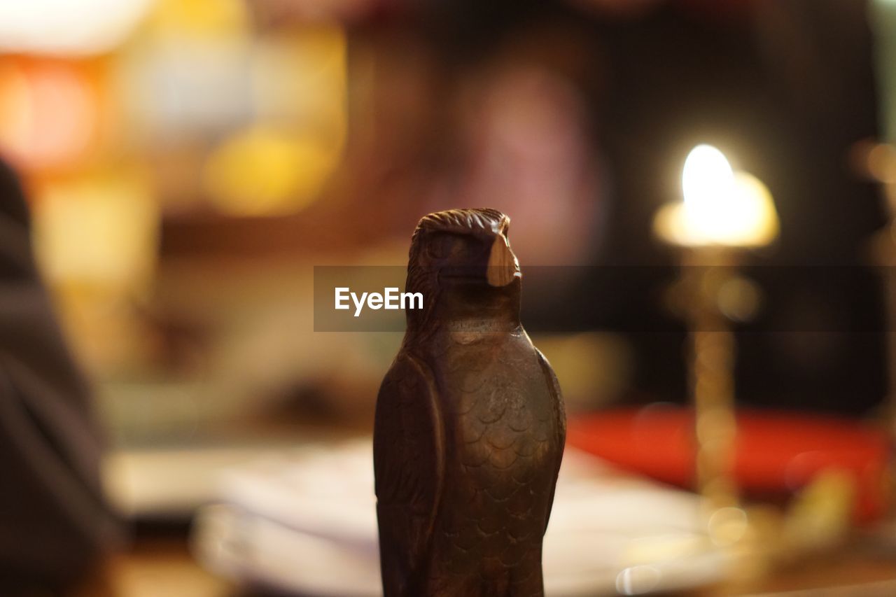 CLOSE-UP OF STATUE ON TABLE AT ILLUMINATED CAFE