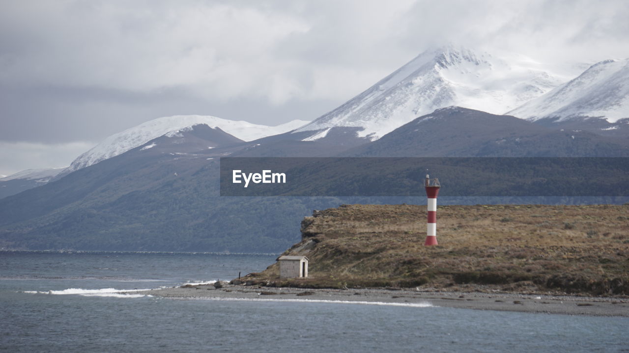 Scenic view of snowcapped mountains and sea against sky