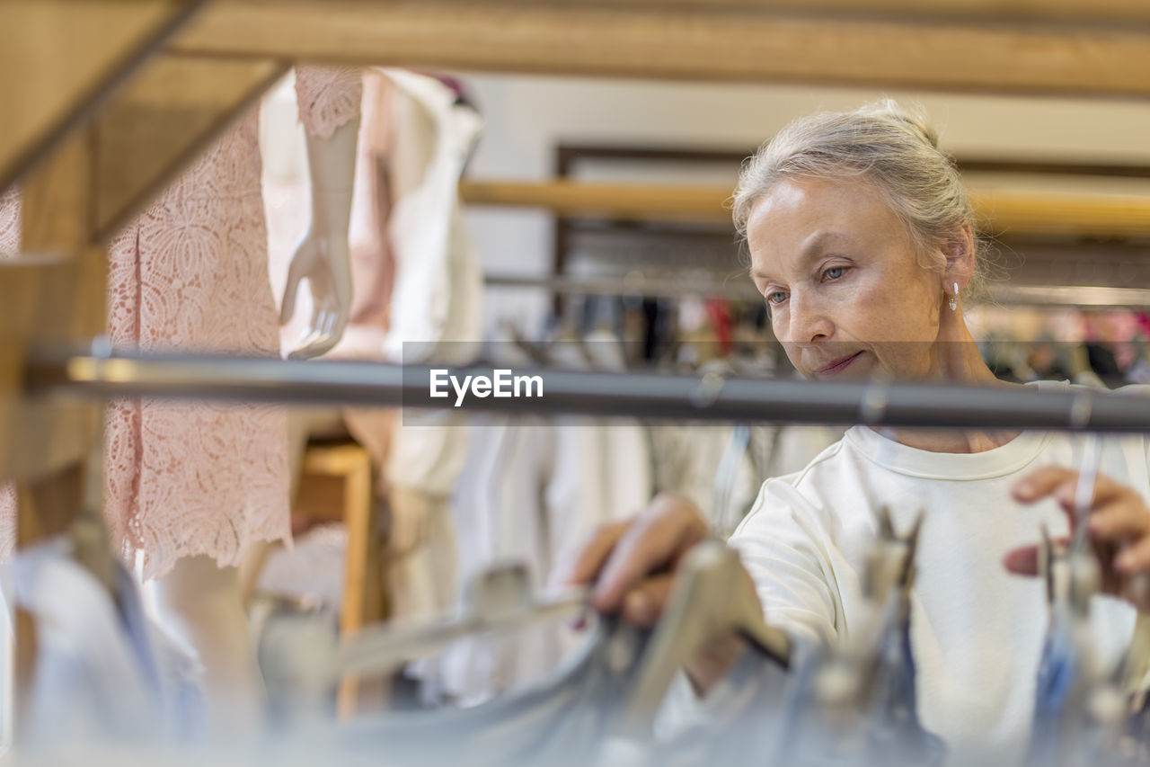 Senior woman shopping for clothes in a boutique