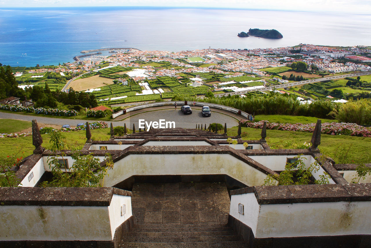 High angle view of townscape by sea against sky