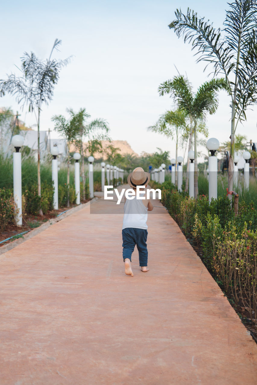 Ethnic kid walking barefoot in street
