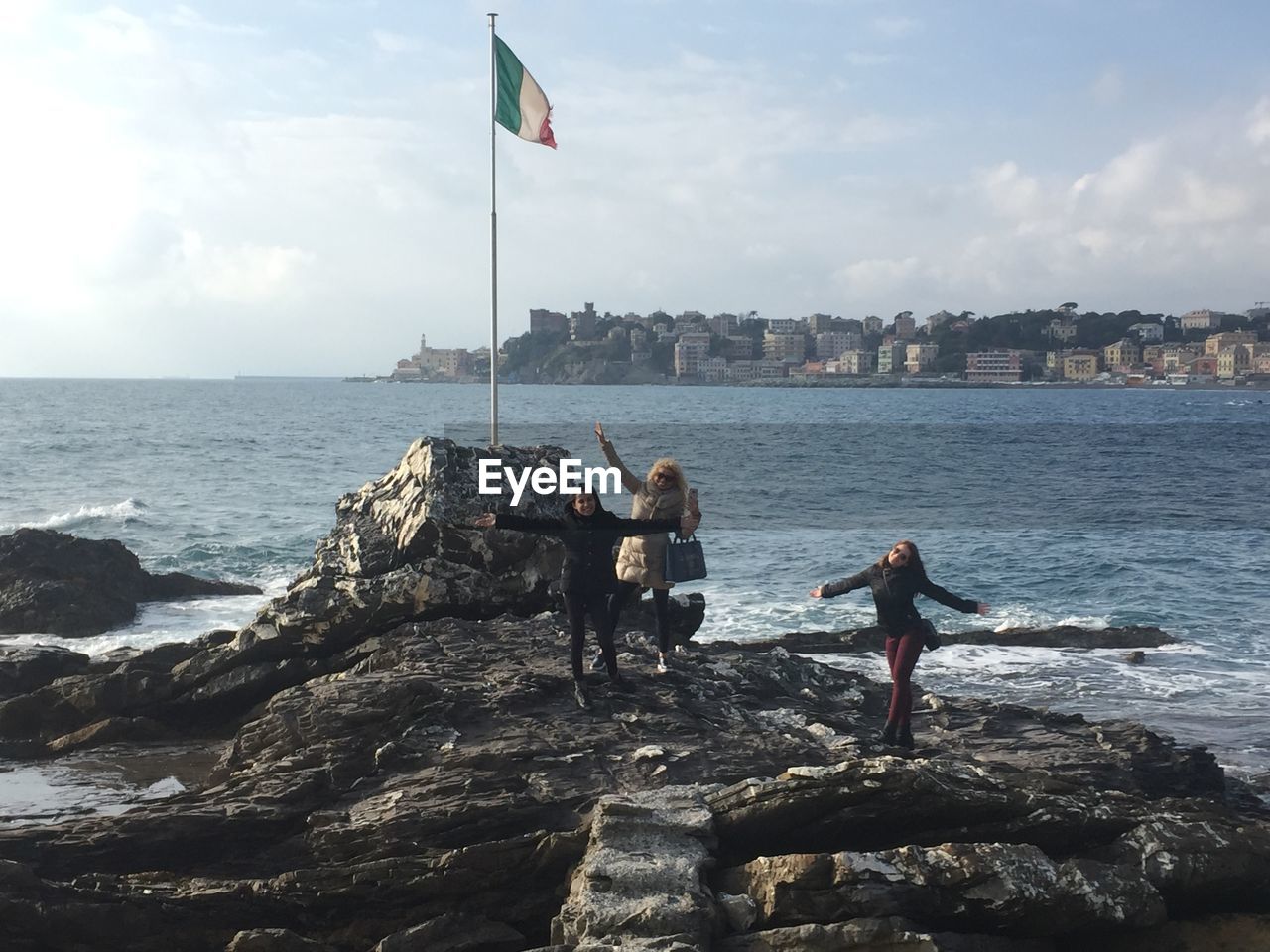 PEOPLE ON BEACH AGAINST SEA