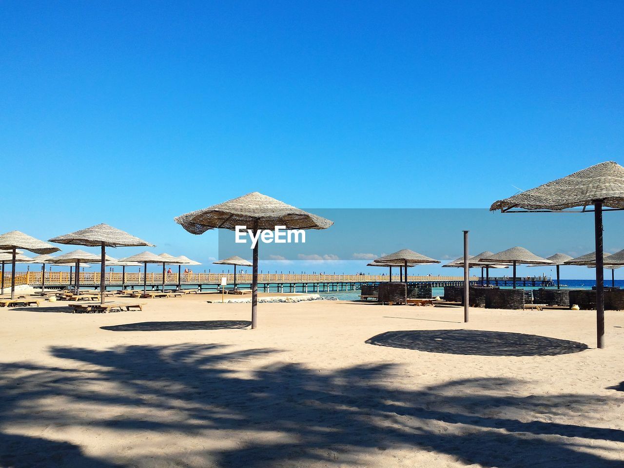 Built structure on beach against clear blue sky