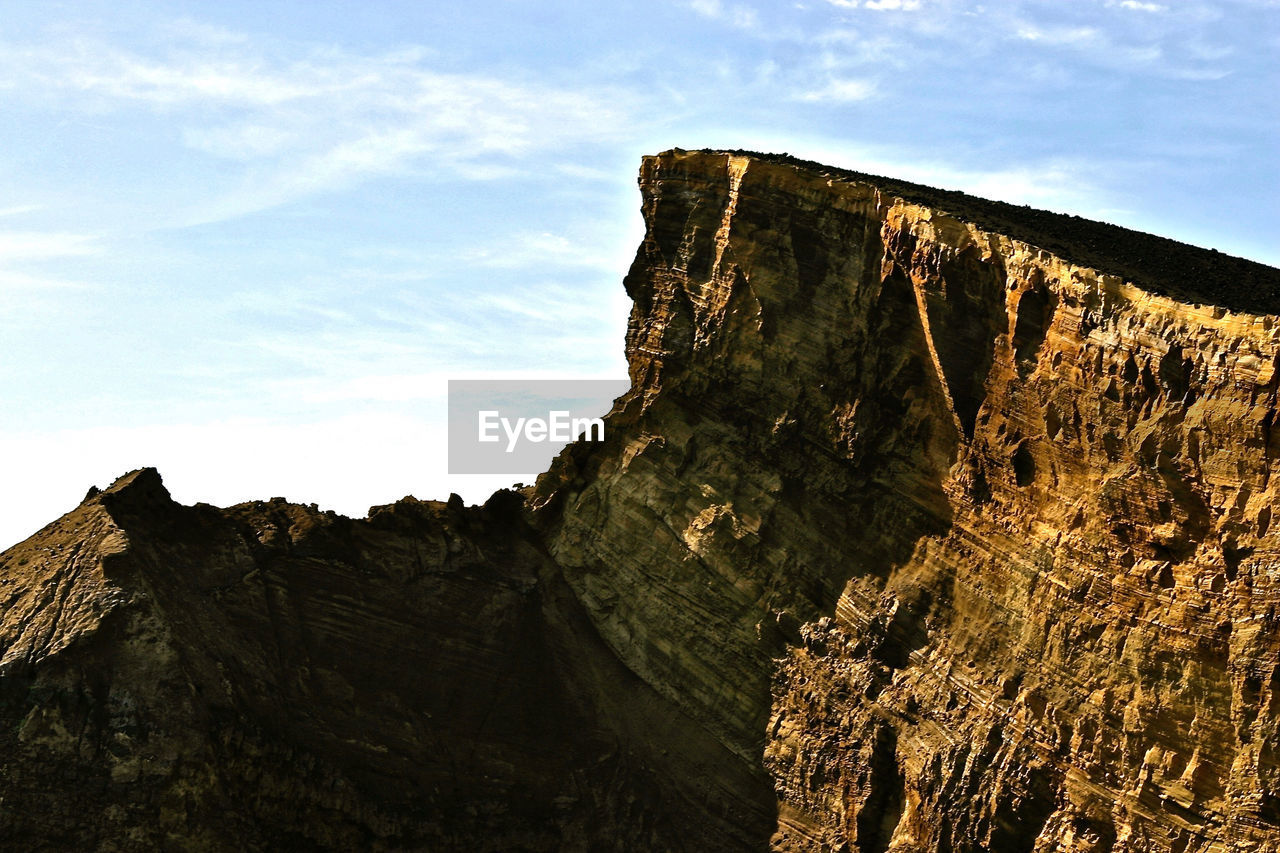 Low angle view of rock formations against sky on sunny day