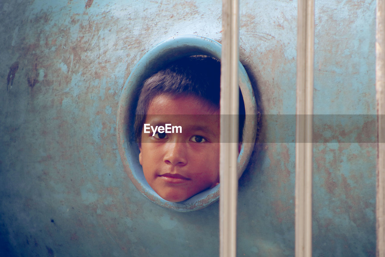 Portrait of boy seen through play equipment