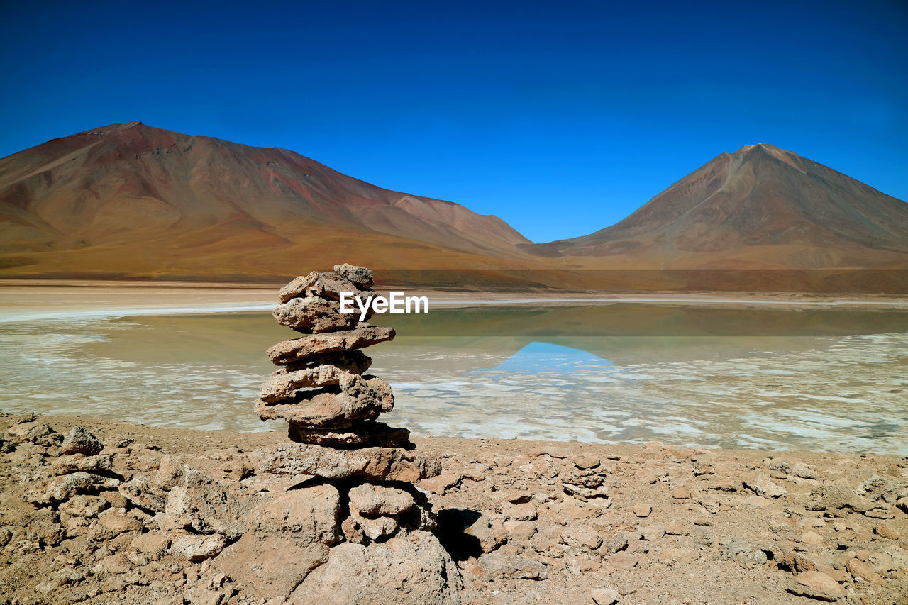 Scenic view of laguna verde or green lake by mountain against blue sky