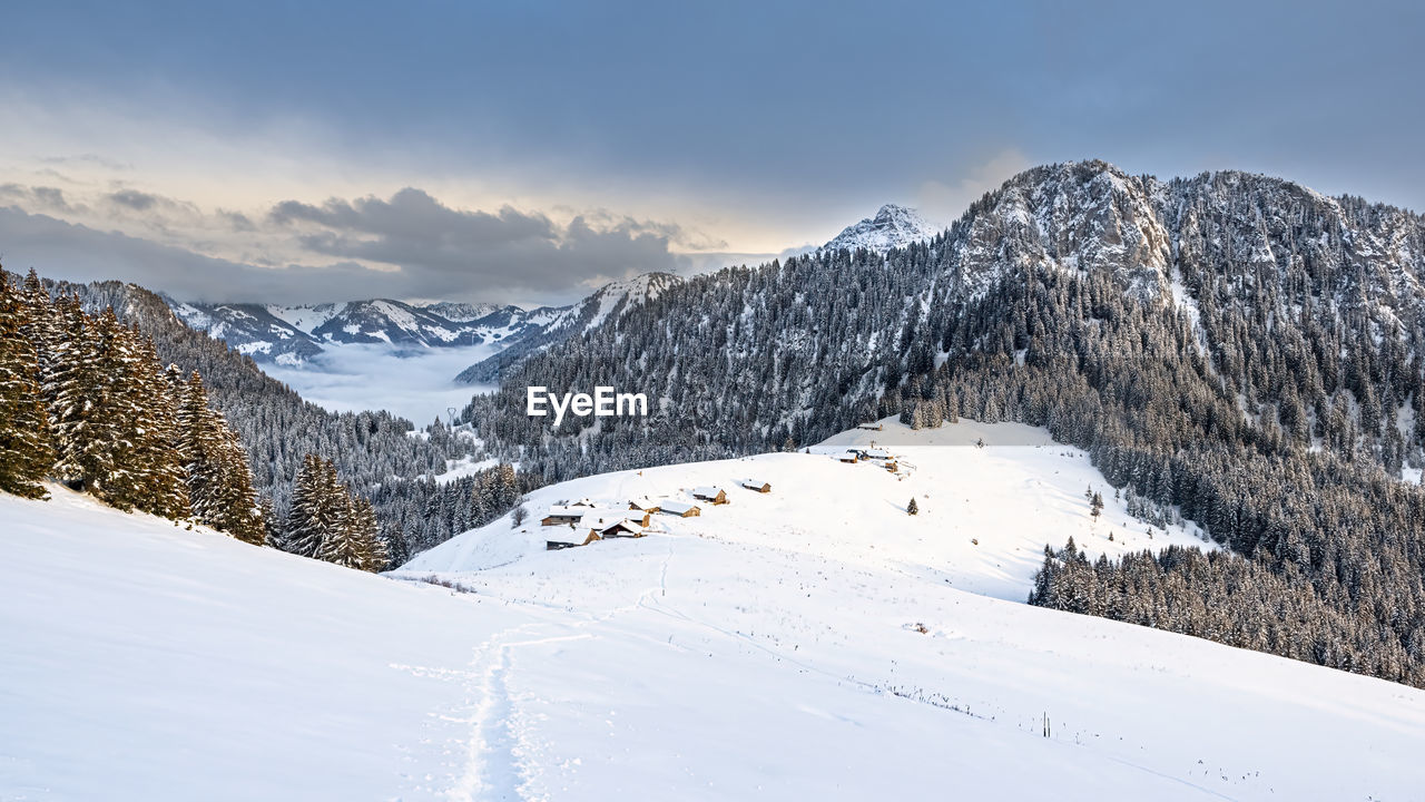 SNOW COVERED MOUNTAINS AGAINST SKY