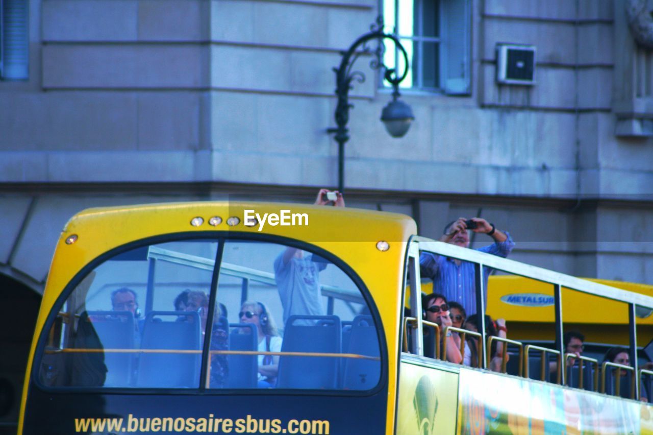 REFLECTION OF PEOPLE IN BUS ON GLASS