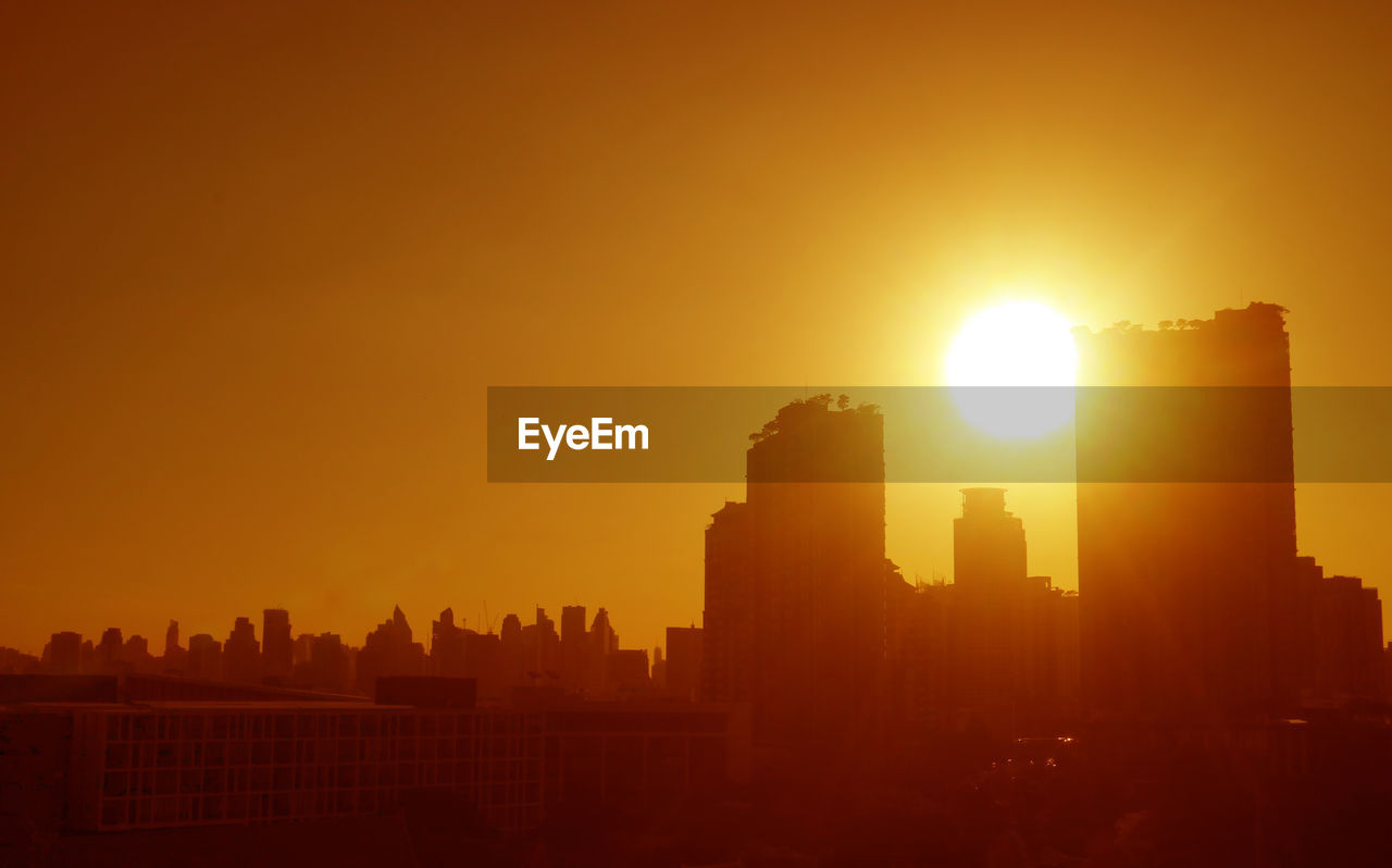 Bright sun over the city skyline in fantastic golden color