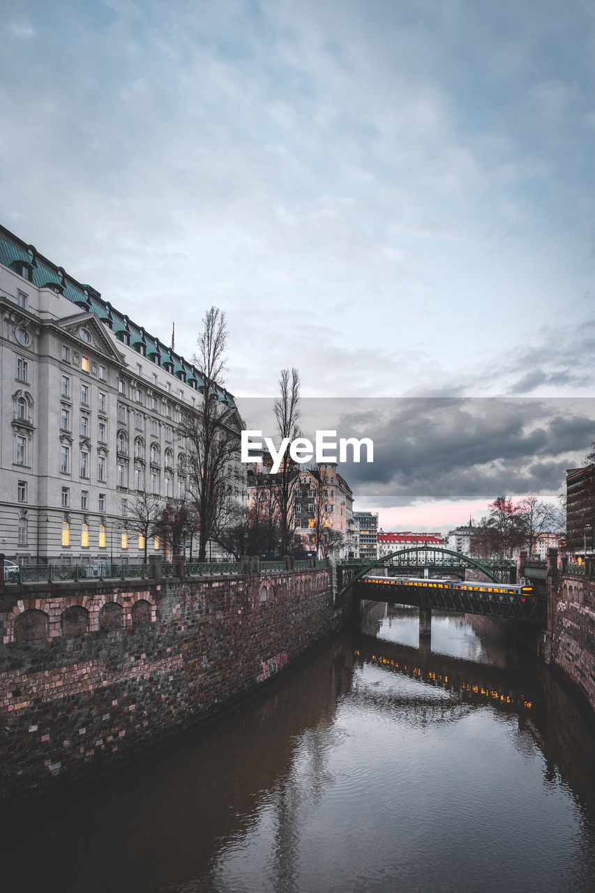 Bridge over river in city against sky