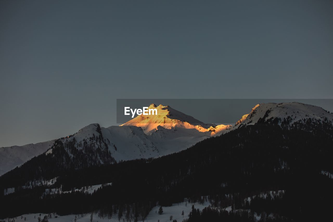 Scenic view of snowcapped mountains against clear sky