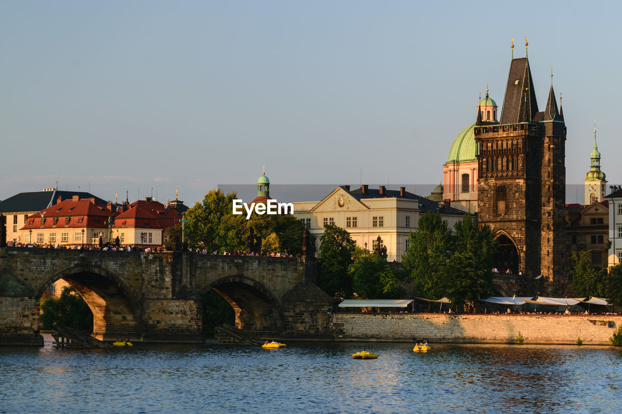 ARCH BRIDGE OVER RIVER AGAINST BUILDINGS