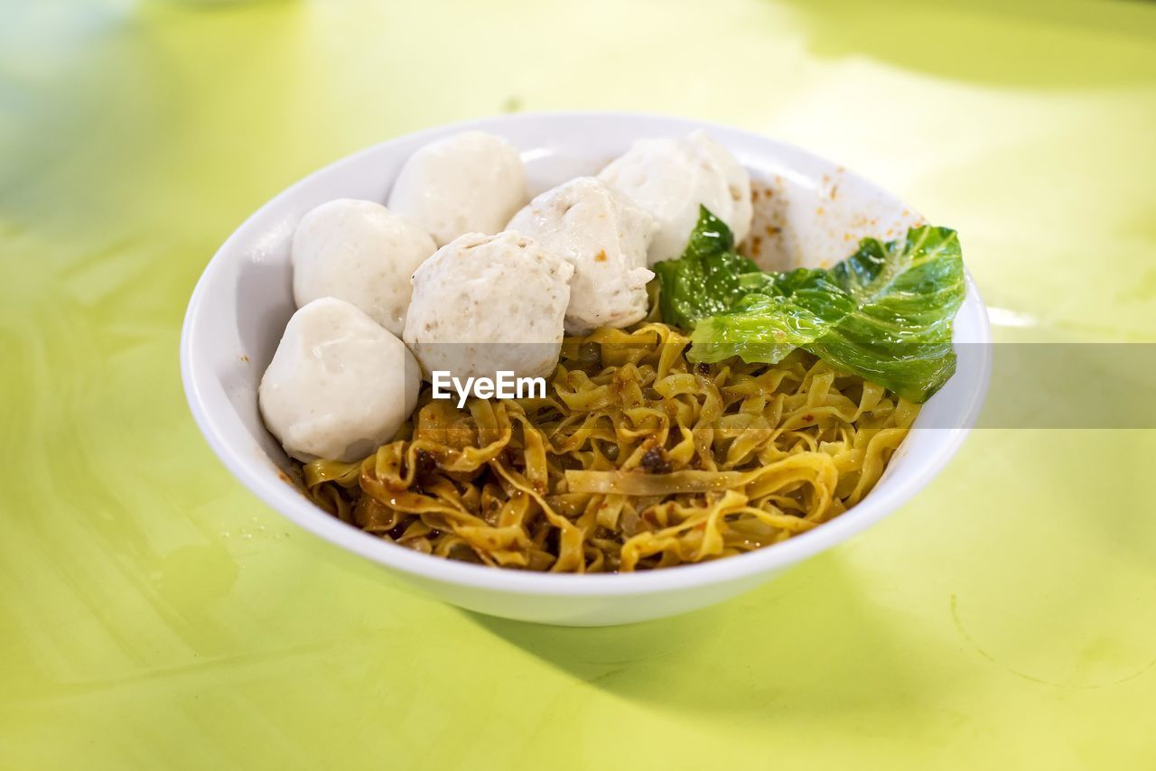 Close-up of fish balls and meatballs with noodles in bowl