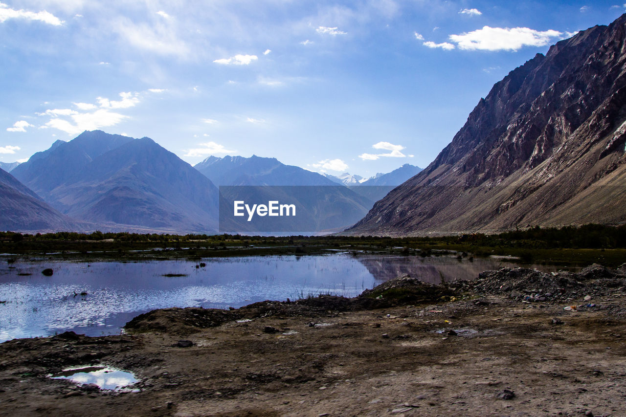 SCENIC VIEW OF LAKE BY MOUNTAINS AGAINST SKY