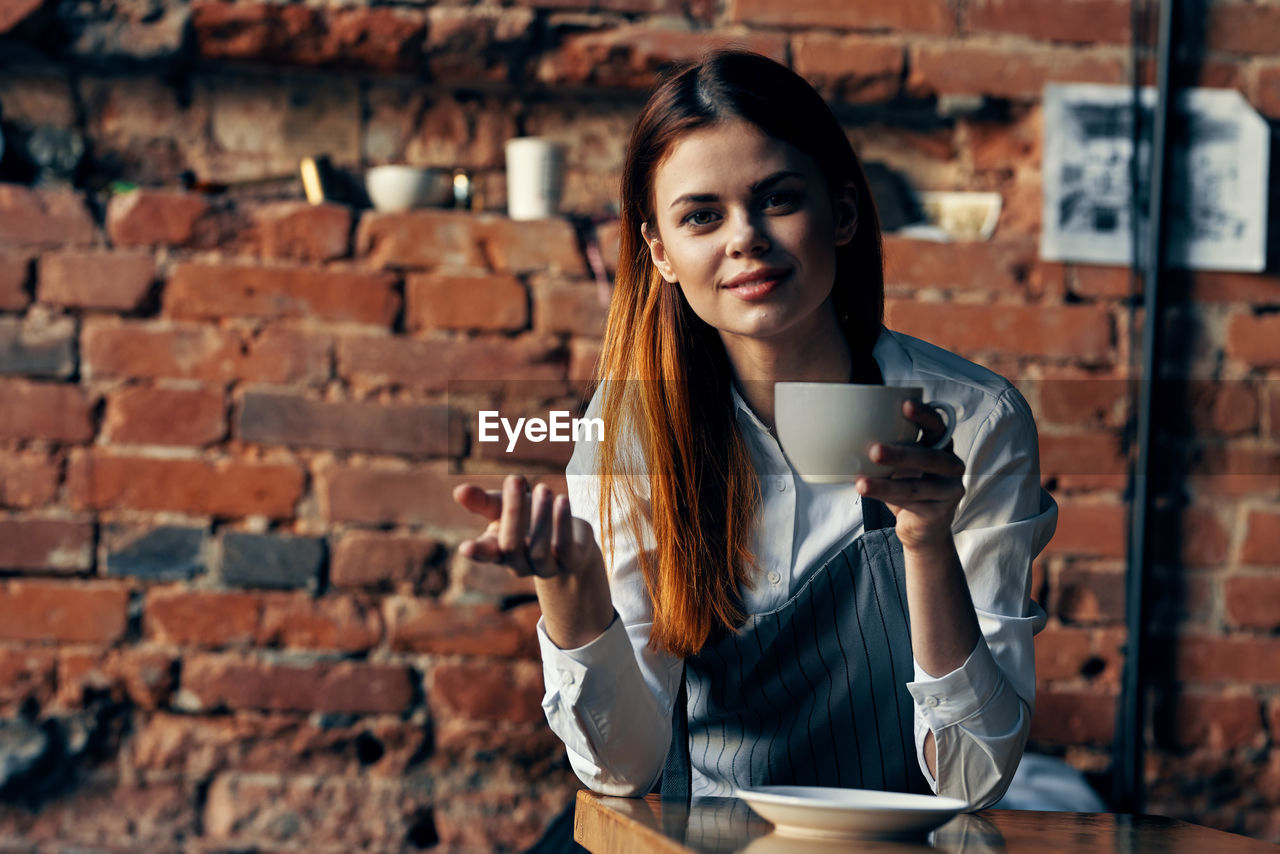 Portrait of woman holding coffee cup