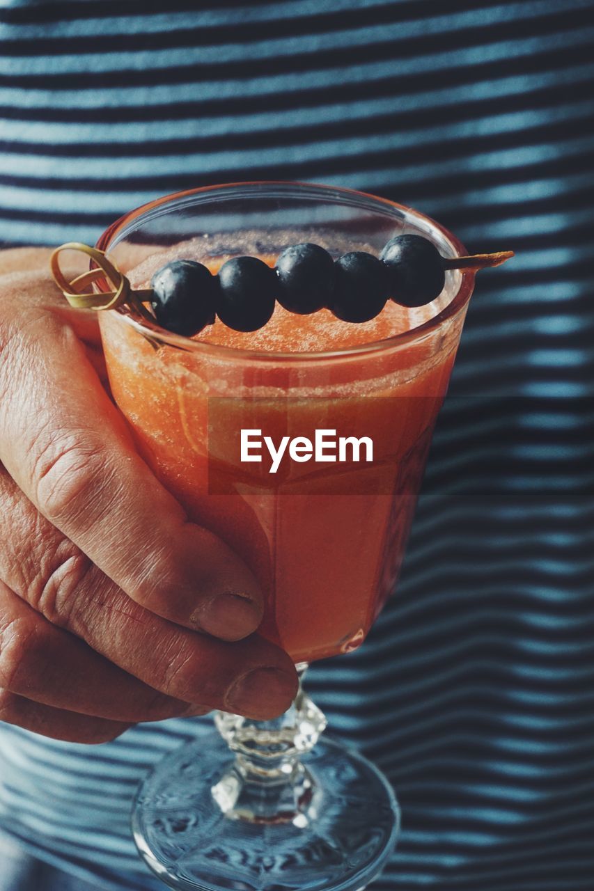 Mature man holding a glass of watermelon smoothie