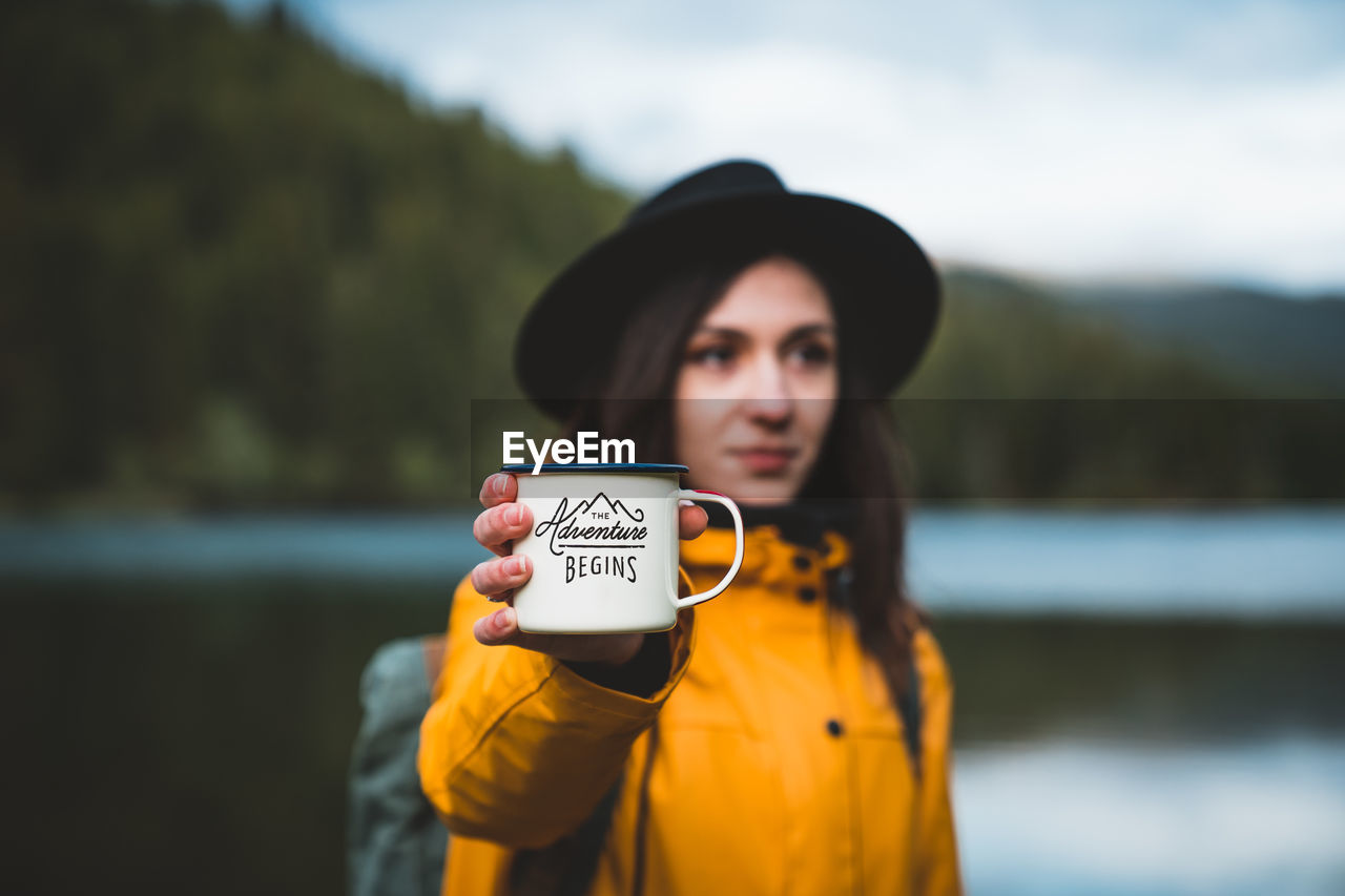 Portrait of woman standing against lake