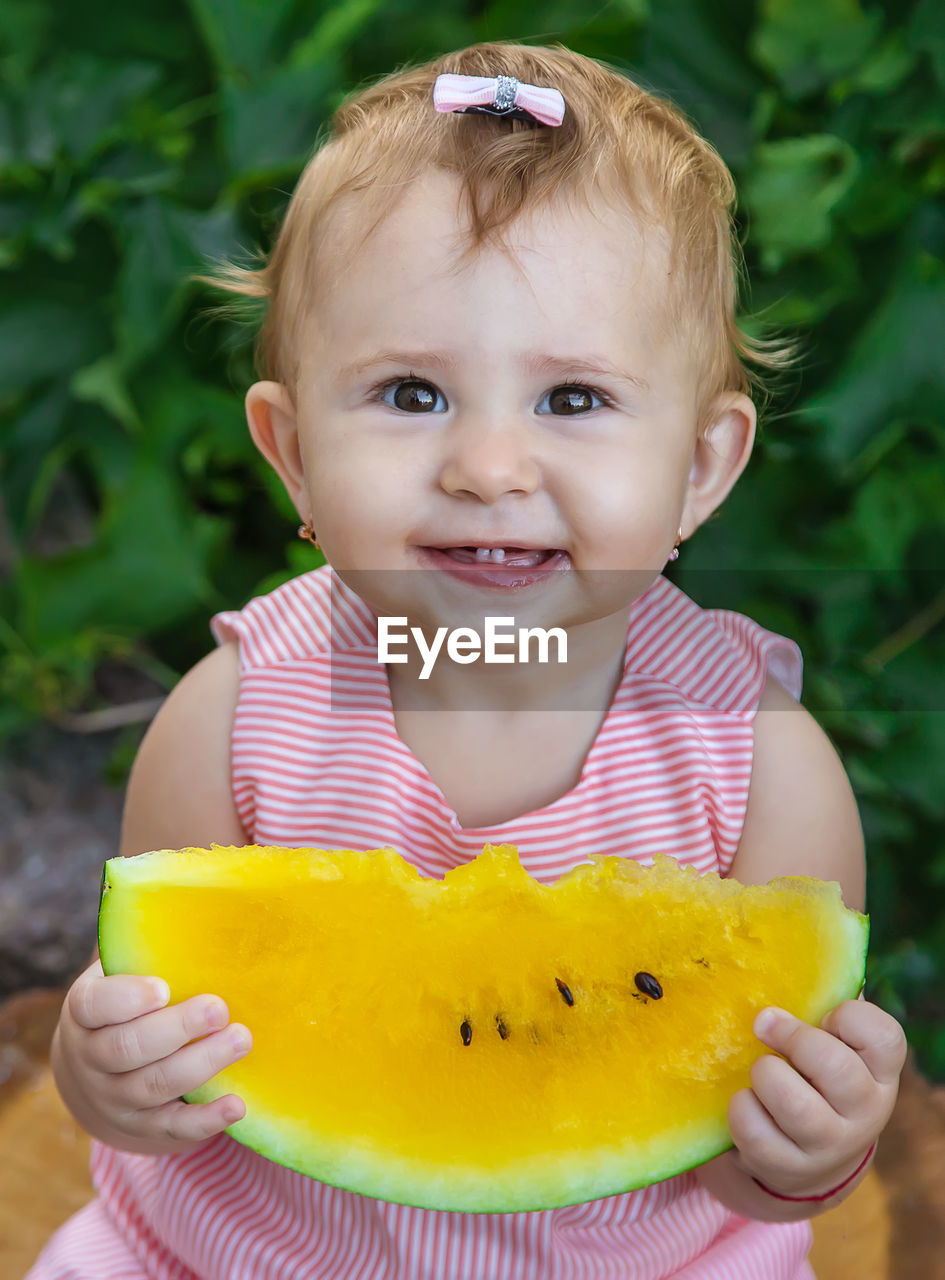 portrait of cute girl holding orange fruit